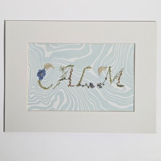 Pressed floral word “CALM” formed with real botanicals on hand-marbled Suminagashi paper, matted artwork by CEDAR Y SAND