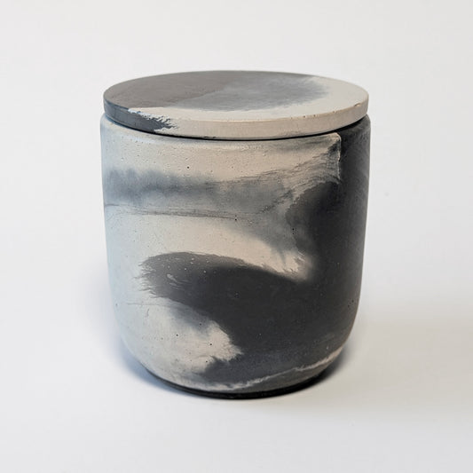 Unlit Nightcap Noir cement candle showing swirls of gray and black marbling for a smoky modern aesthetic.