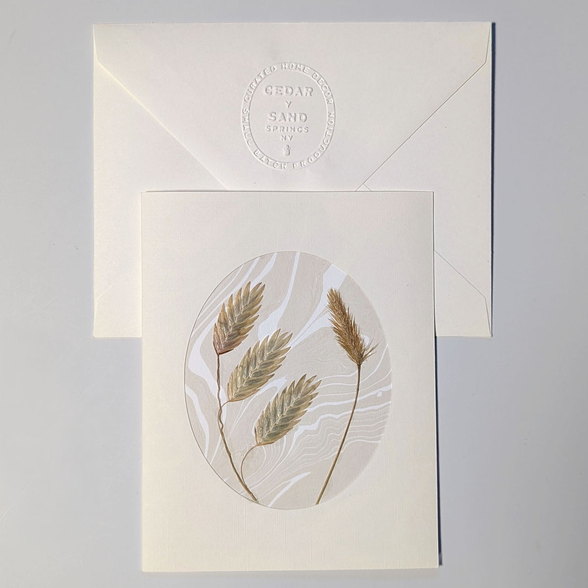 Walking Dunes Oat Grass handmade Suminagashi notecard featuring pressed golden grasses on neutral marbled paper with embossed CEDAR Y SAND envelope.