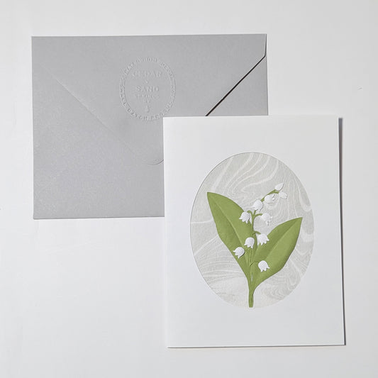 Lily of the valley handmade notecard with embossed Cedar y Sand envelope on neutral background
