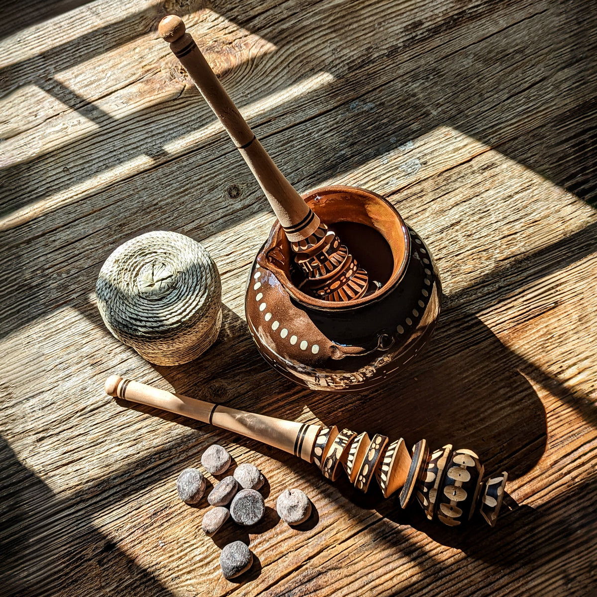 Chocolate bolitas and it's palm woven basket with olla de barro and wooden molinillo, styled for Mexican hot chocolate tradition
