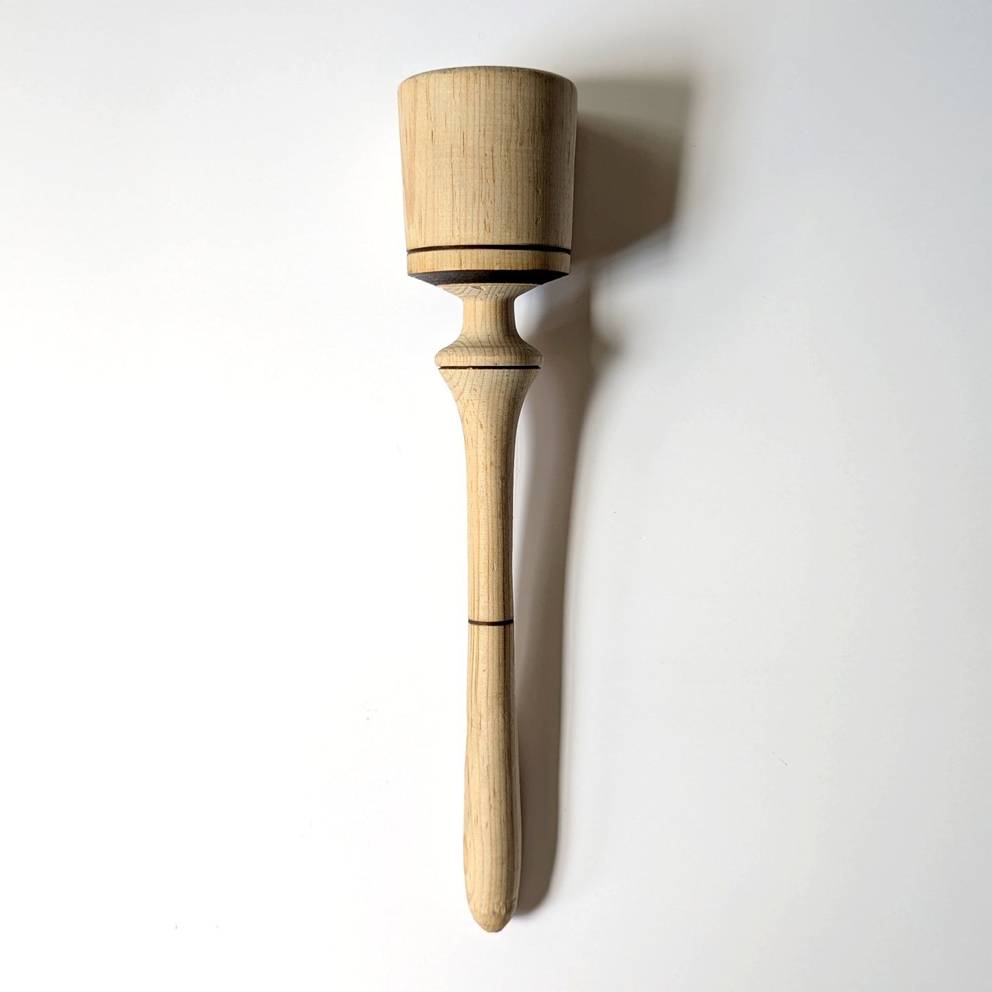 Hand carved wide wooden pestle with burn accents details on a white background