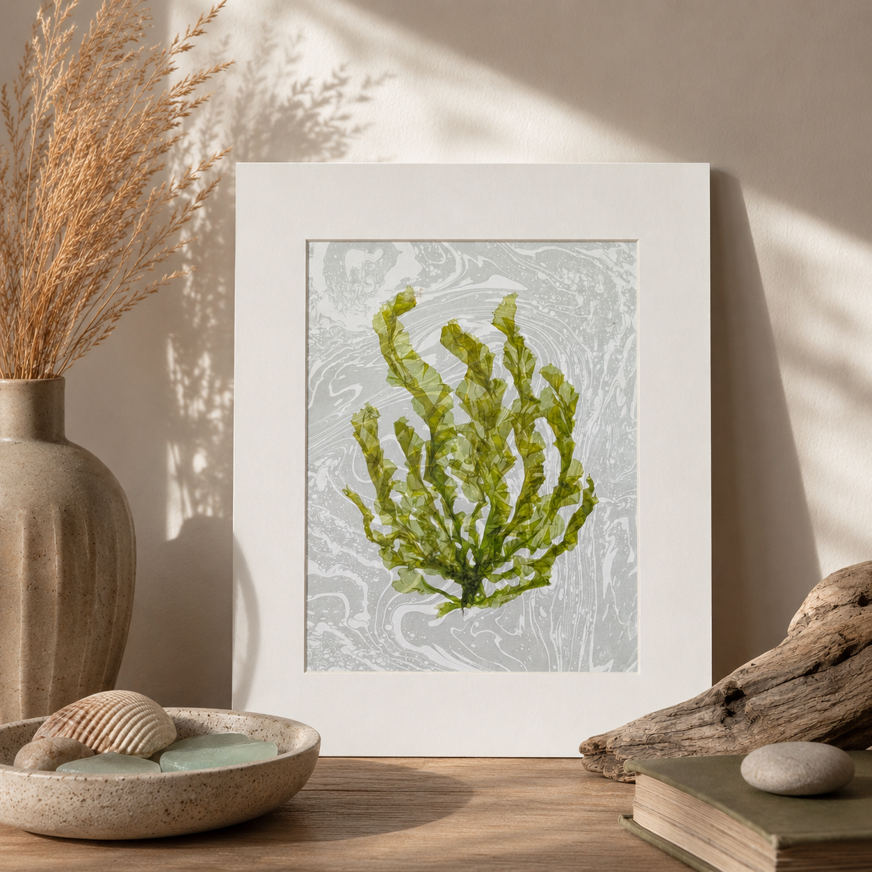Green Current pressed seaweed artwork displayed in a coastal-inspired interior with driftwood, shells, and natural textures.