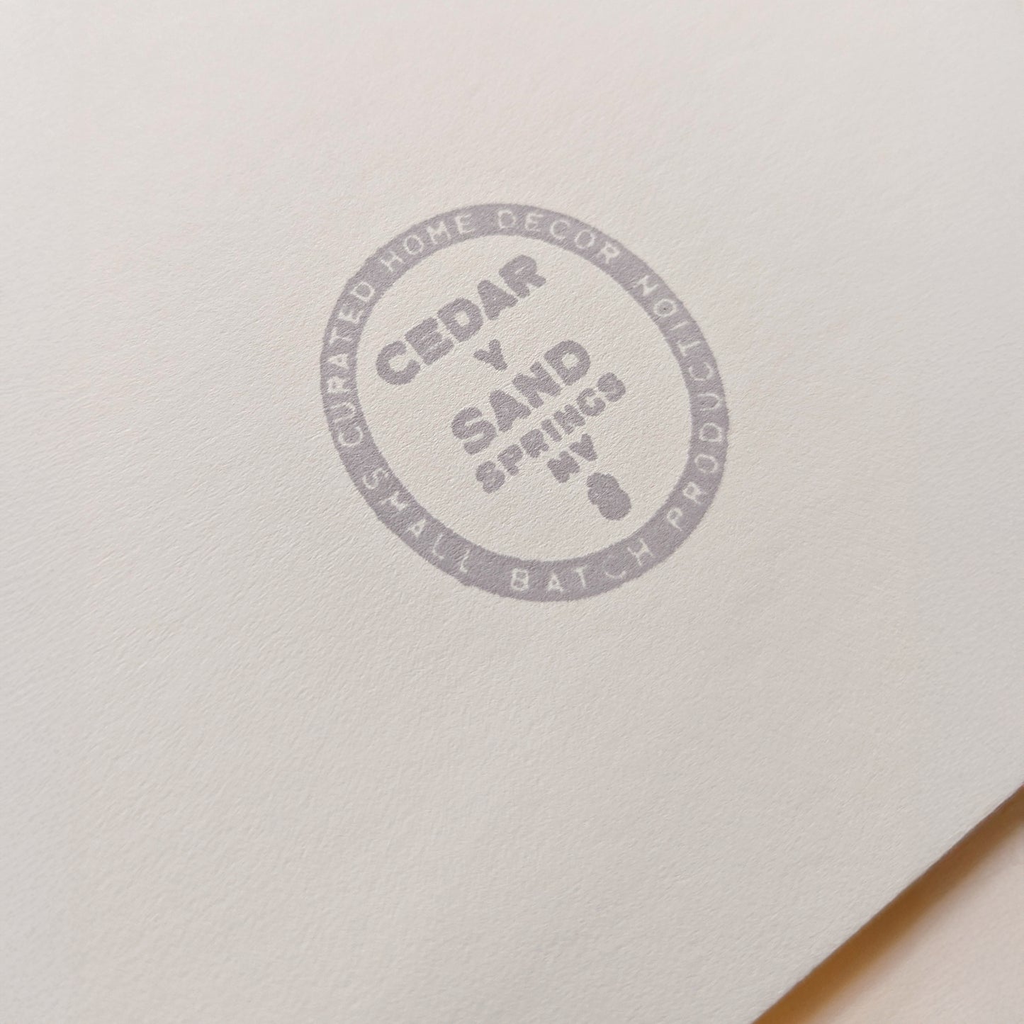 Cedar Y Sand insignia gray back stamp on the backing mat