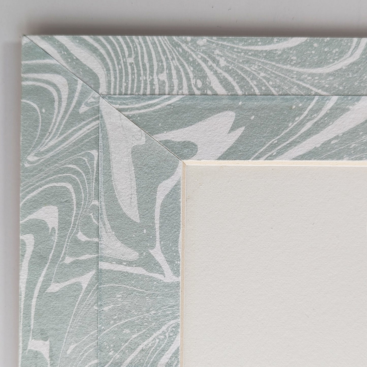 Close view of blue-white suminagashi marbled Hosho paper mat around painting.