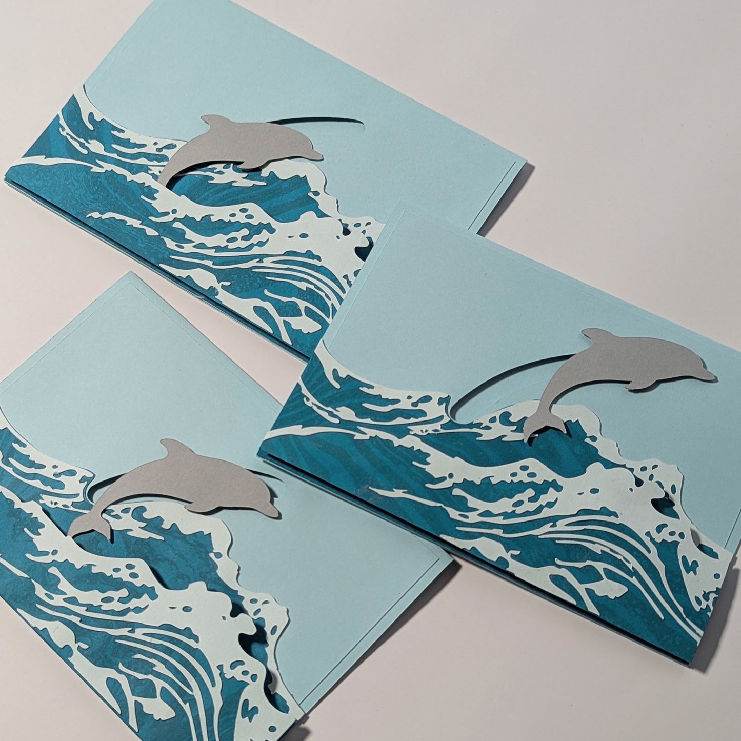 Group of Surfin’ Flipper slider notecards displayed together, showing some of the different dolphin positions on the glider