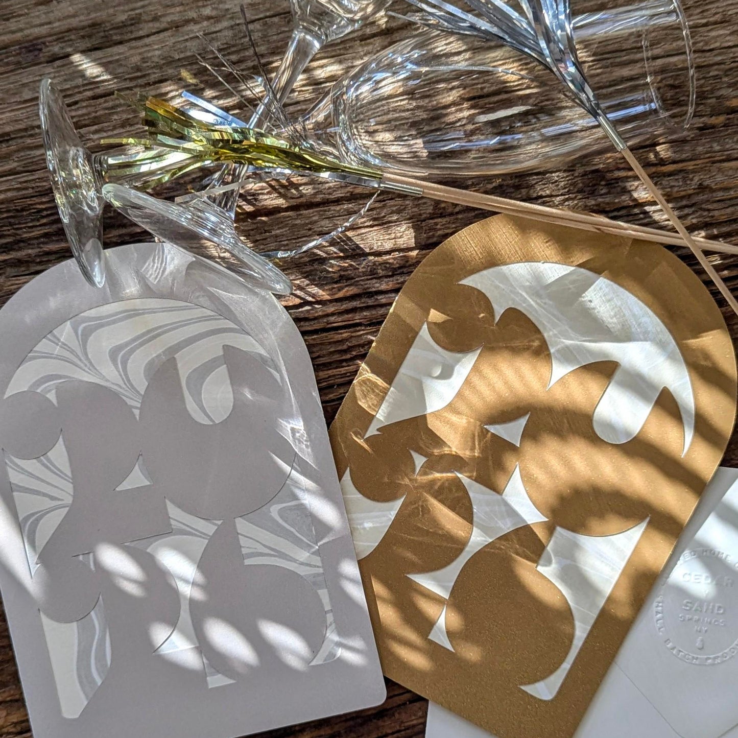 silver and metallic gold shimmering 2026 notecards displayed with champagne flutes and New Years sparkle