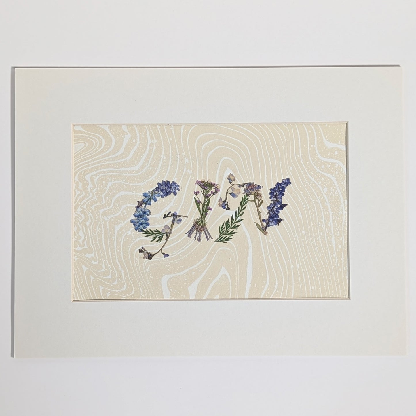 Pressed floral word “GIN” made with pressed botanicals on Suminagashi marbled paper, unique handmade word artwork