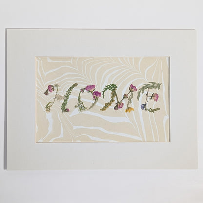 Pressed floral word “HOME” created with natural botanicals on Suminagashi marbled paper, one-of-a-kind matted art