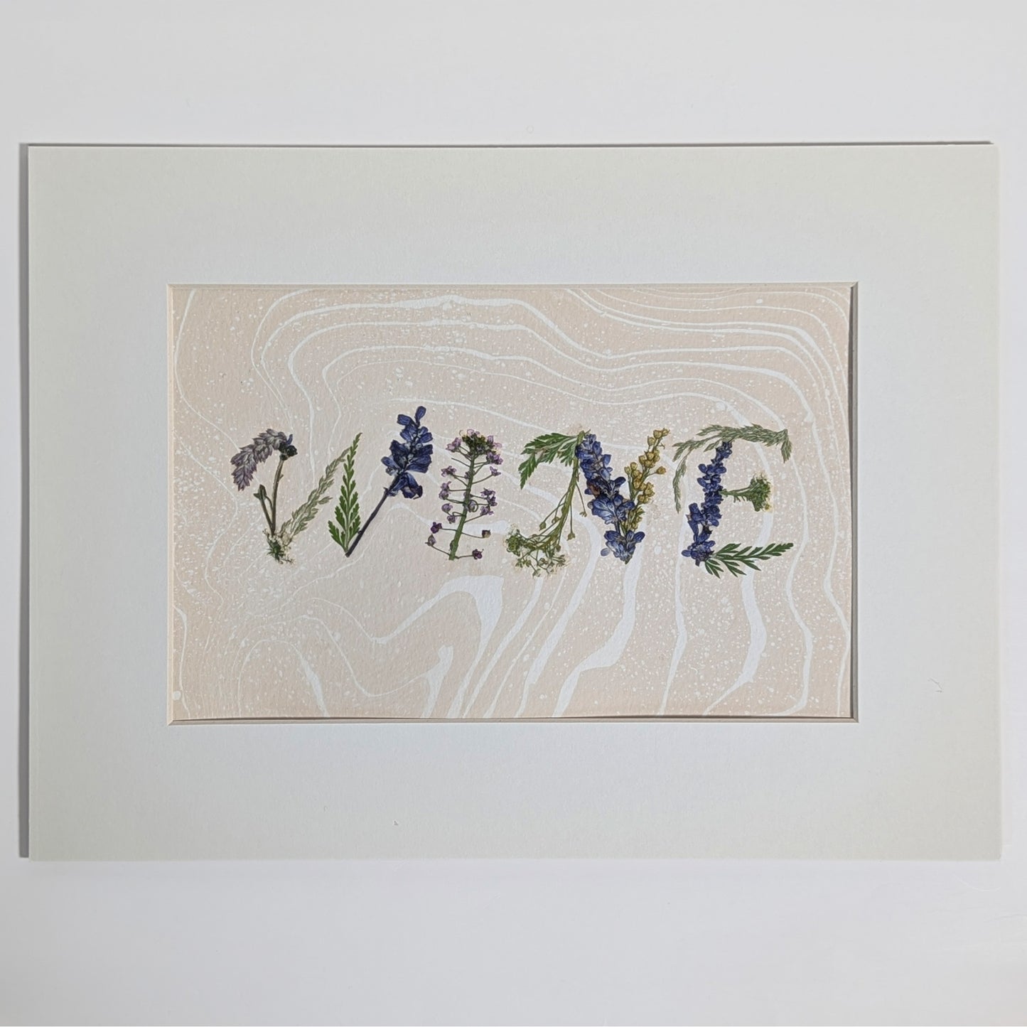 Pressed floral word “WINE” composed from real flowers on hand-marbled Suminagashi paper, framed botanical word art