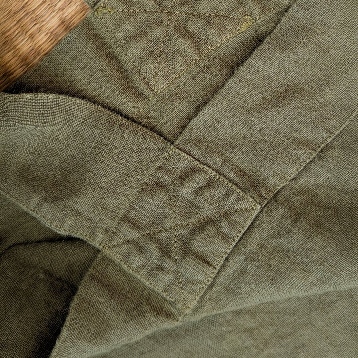 Close-up detail of reinforced stitching on olive linen Escapade tote handle attachment