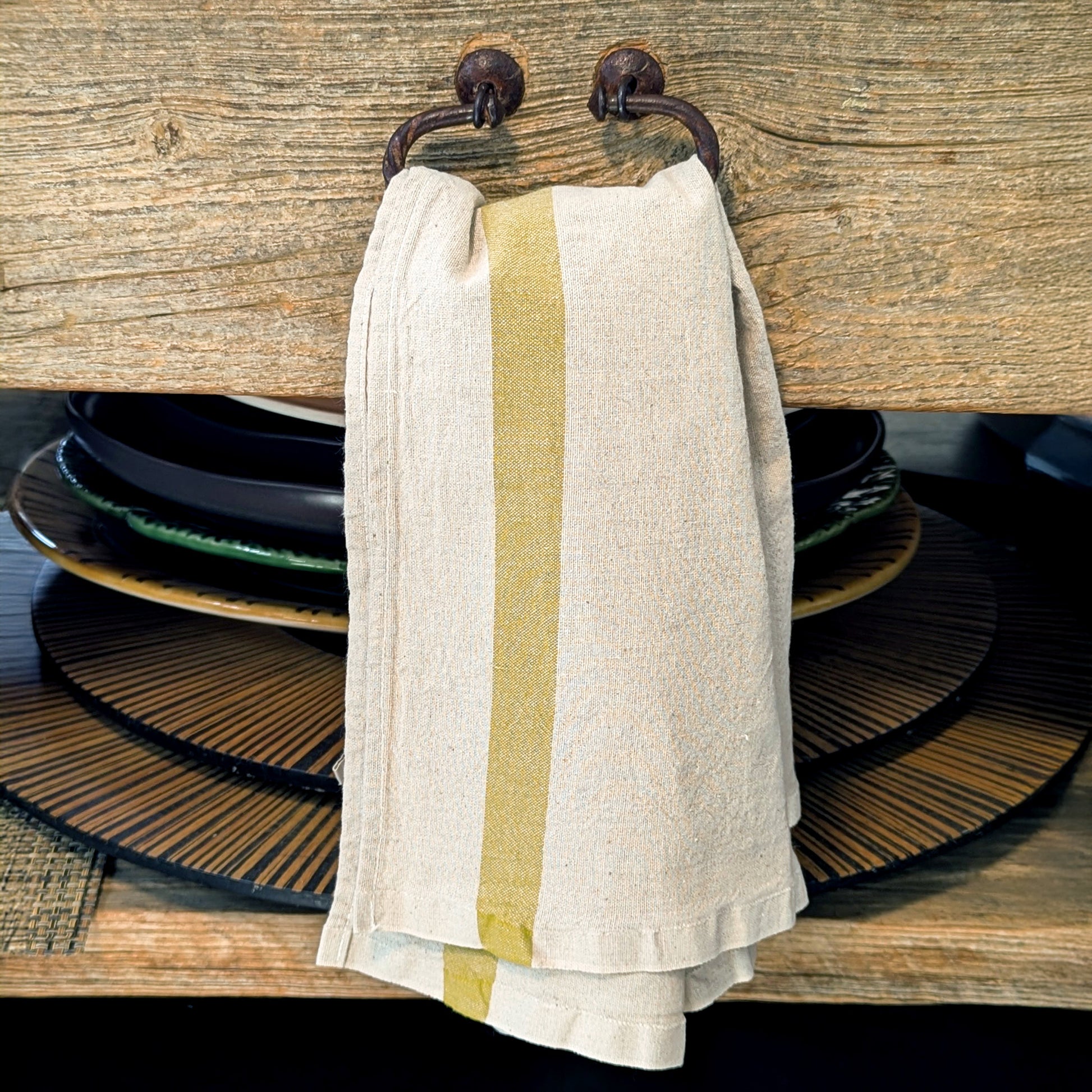Bergamot stripe Phenix kitchen towel folded and layered over vintage wooden drawer pull