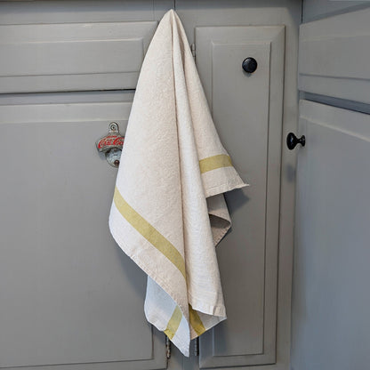 French linen-cotton Phenix bergamot tea towel hanging on painted cabinet door in soft neutral kitchen setting