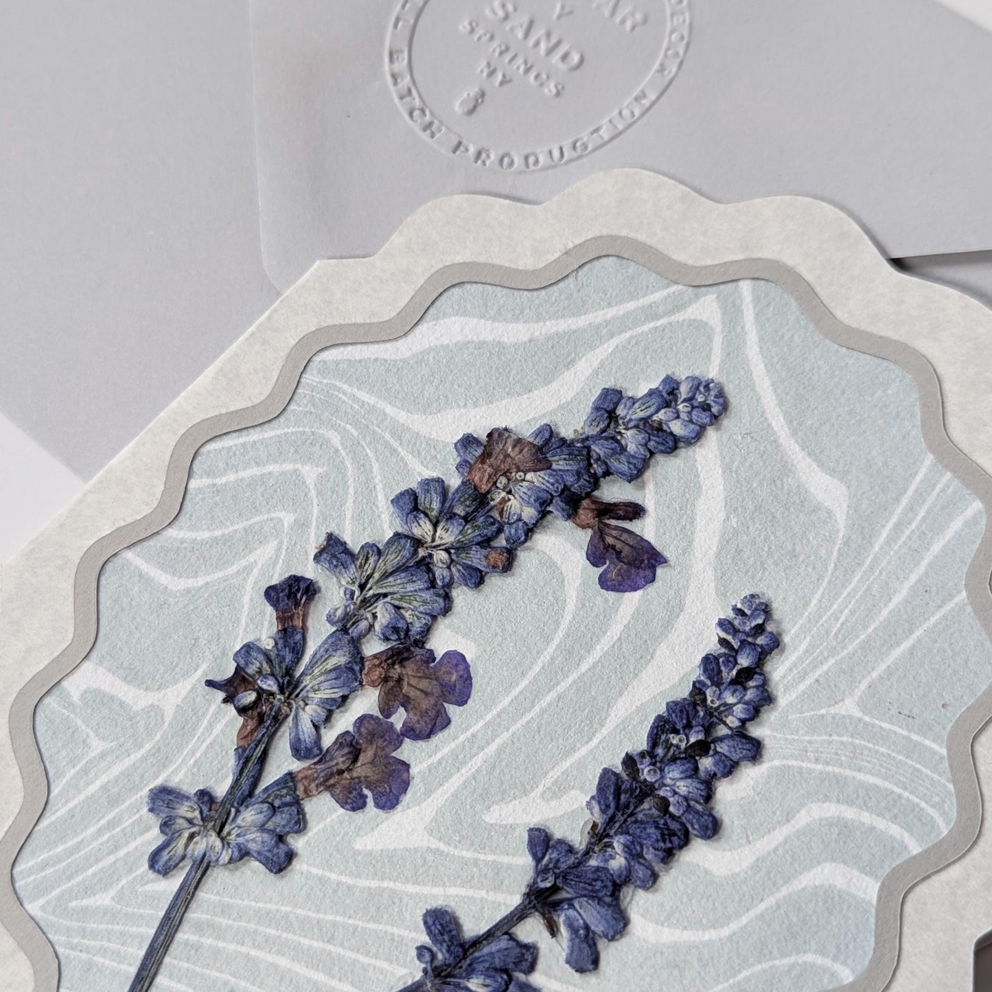 Detail view of pressed lavender flowers on Suminagashi marbled washi paper notecard