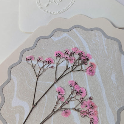 Close-up of pressed pink florals layered over marbled washi paper on Flora of Affection notecard