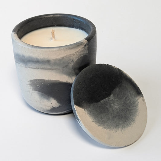 Detail shot of Nightcap Noir soy candle with lid resting aside, showing the unique texture and color pattern of each hand-cast piece.