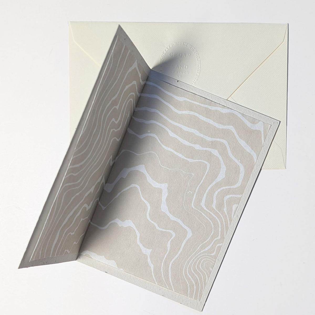 Interior of Poetry in Bloom botanical notecard displaying flowing cream and ivory Suminagashi marbling on removable Japanese Hosho paper.