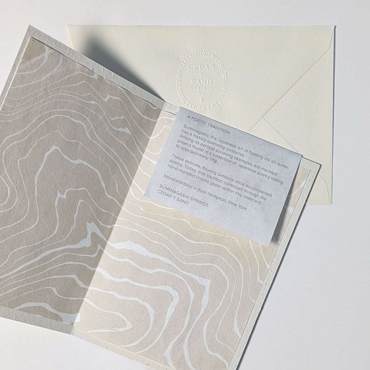 Open Poetry in Bloom notecard revealing a hand-marbled Japanese Hosho paper liner and insert describing the poetic history of Suminagashi.