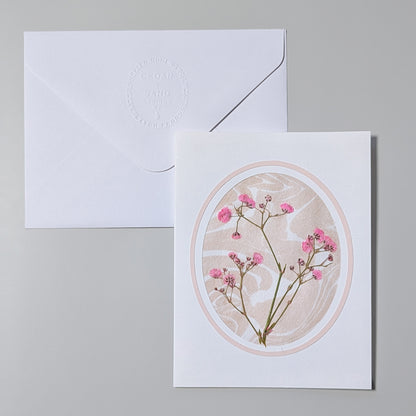 Handmade Suminagashi pressed flora notecard with pink wildflowers framed in an oval cameo on marbled Hosho paper with embossed envelope
