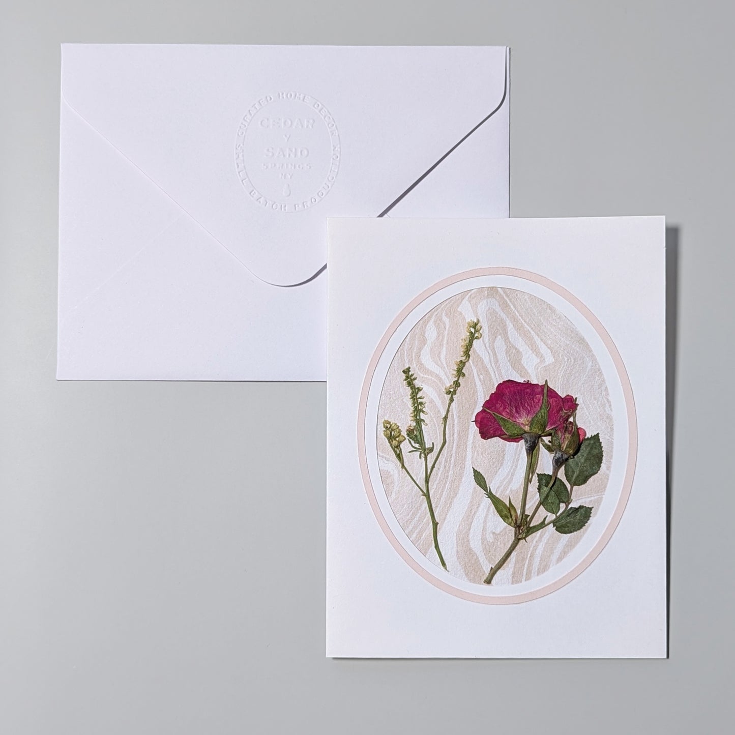 Handmade Suminagashi pressed flora notecard with red rose and wild stems framed in an oval cameo on marbled Hosho paper with embossed envelope