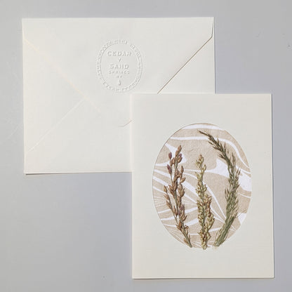 Walking Dunes Gathered notecard with an arrangement of pressed grasses in muted green, wheat and lavender tones over neutral hand-marbled Suminagashi paper.