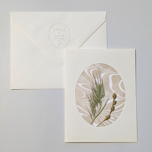 Walking Dunes Wisp handmade notecard featuring fine pressed grasses and small seed heads over warm neutral hand-marbled Suminagashi paper.