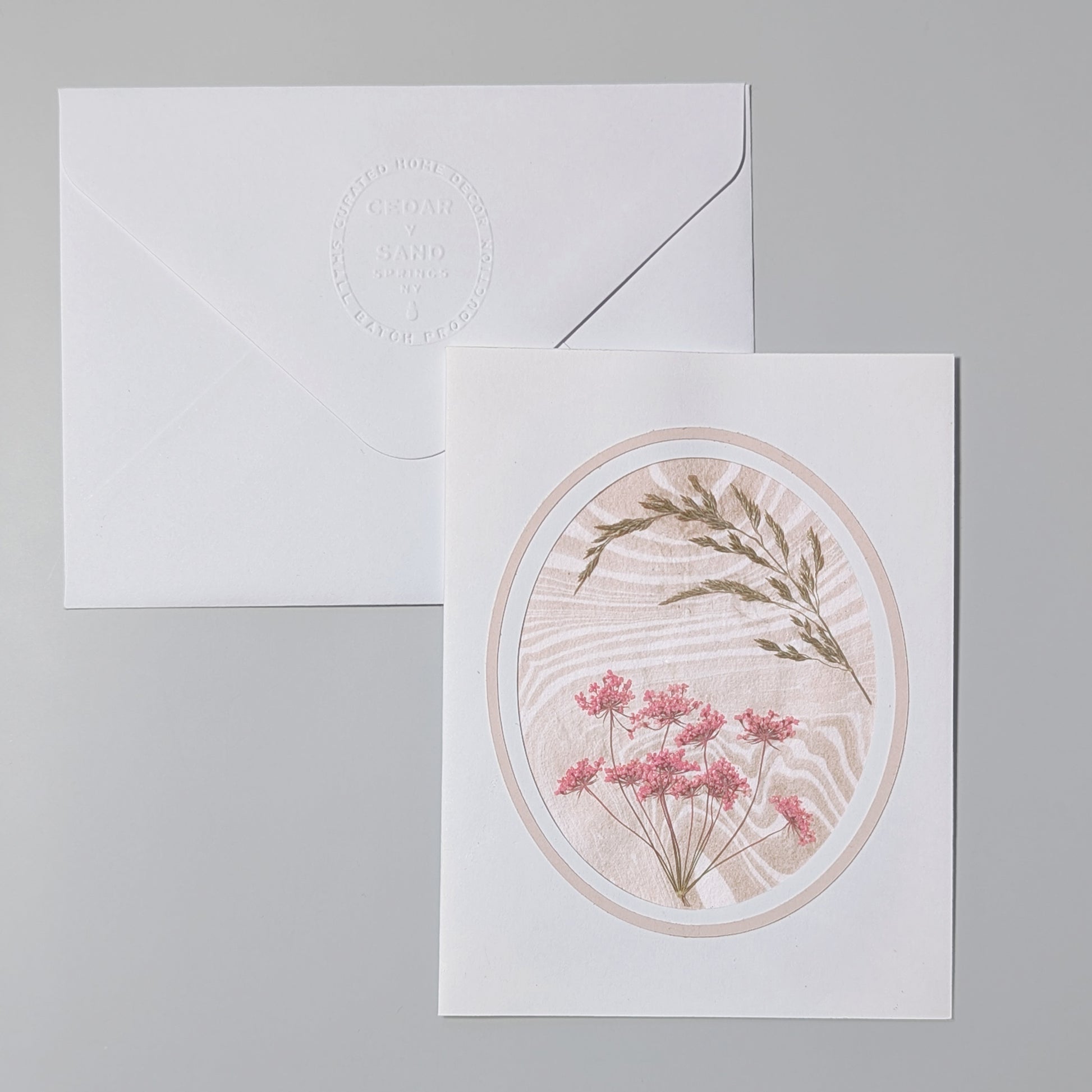 Greeting card with floral design and matching envelope on a white background