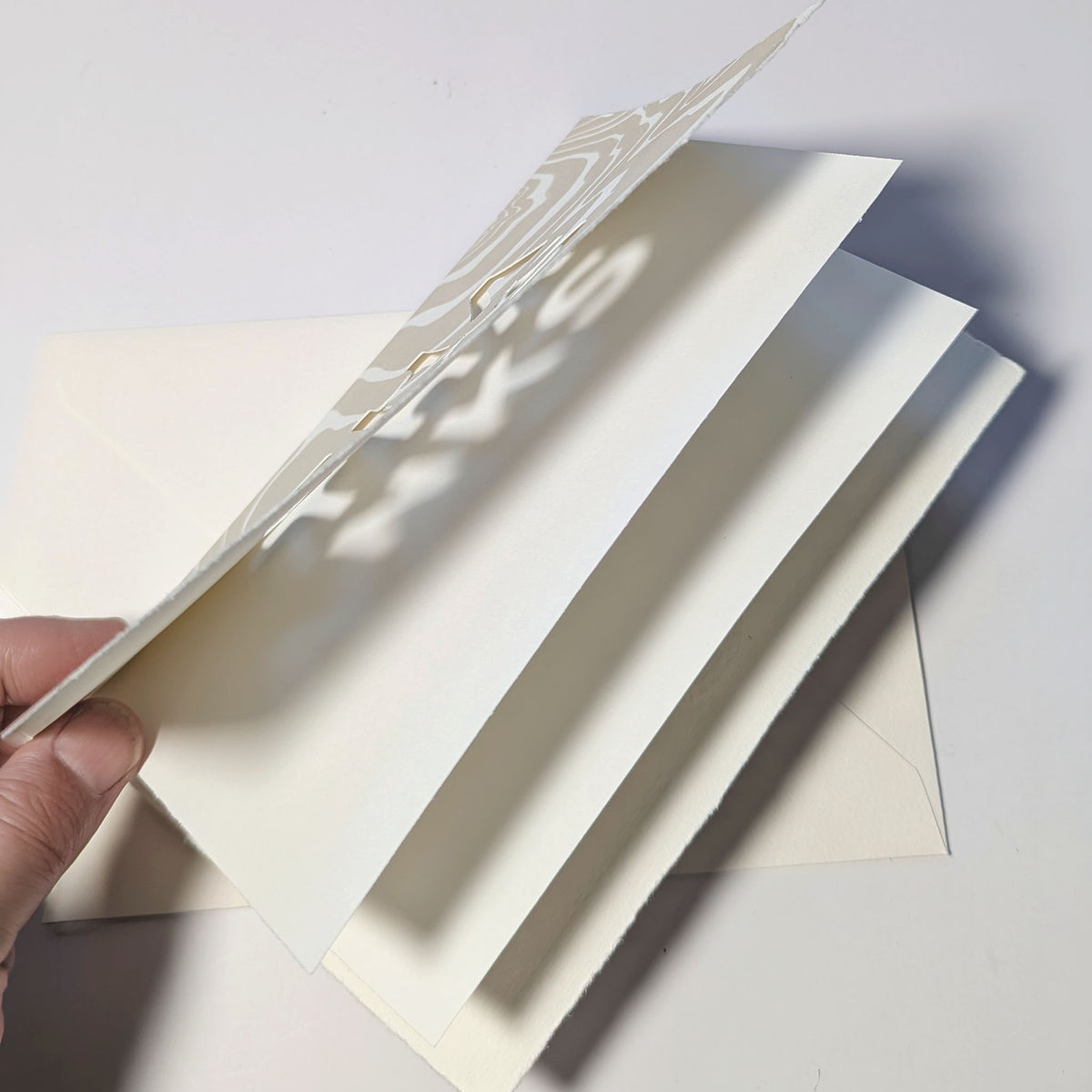 Handmade Suminagashi Thanks Notecard opened to reveal its natural-colored blank writing liner and cut-out lettering.
