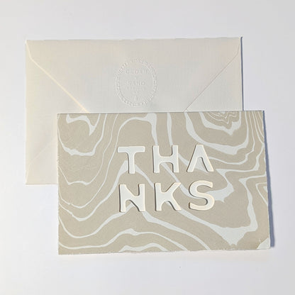 CEDAR Y SAND Thanks Notecard in Oat, featuring natural Suminagashi marbling, cut-out THANKS lettering and embossed envelope.