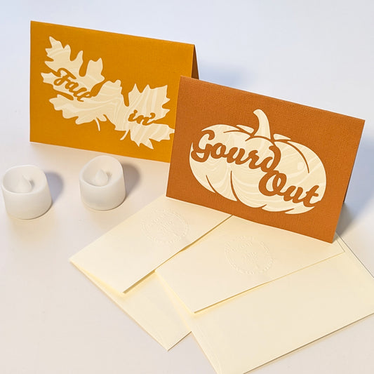 CEDAR Y SAND’s “Gourd Out & Fallin’” lantern card set, featuring two autumn-colored paper-cut notecards with marbled suminagashi paper backing, embossed envelopes and 2 LED Tealights