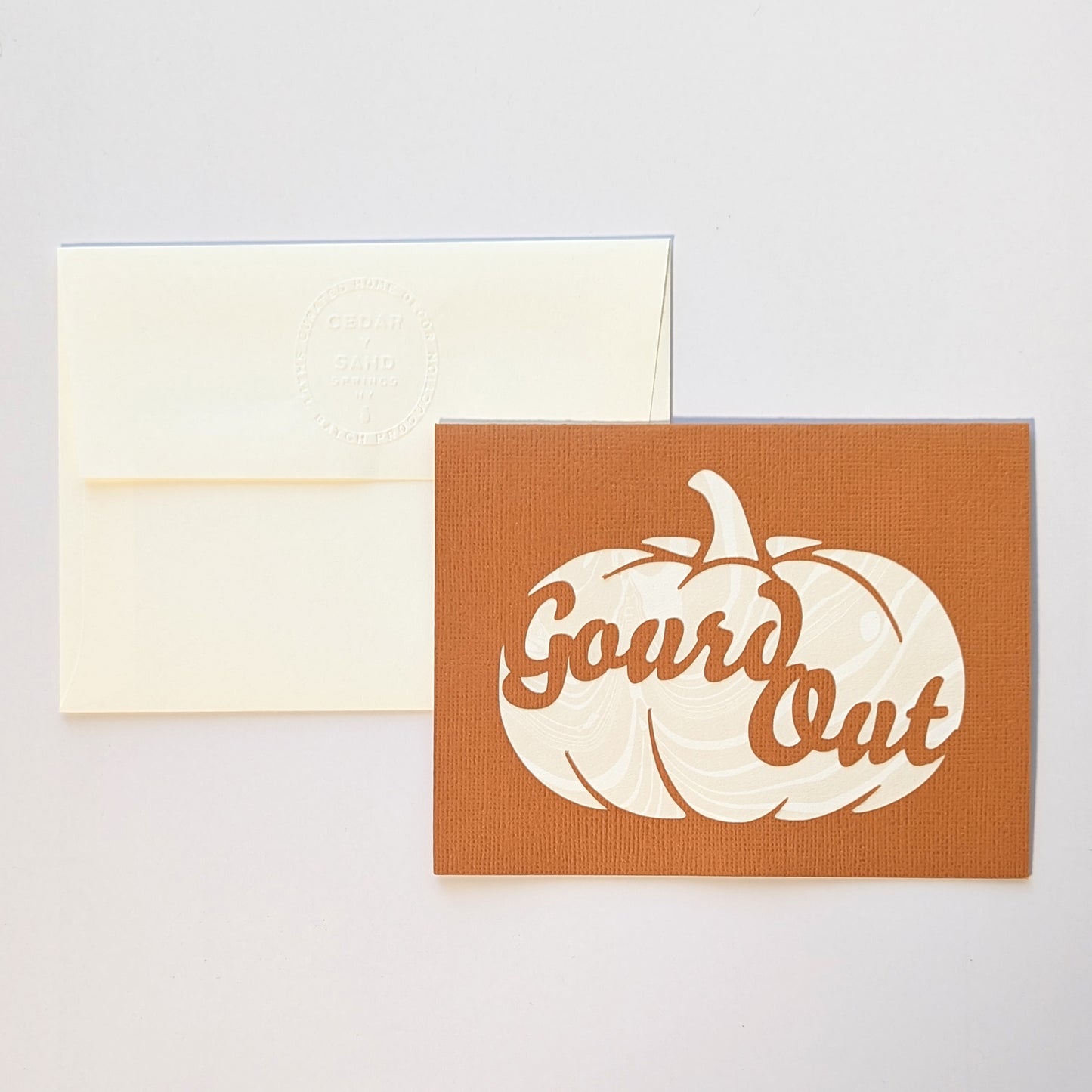 Paper cut Gourd Out notecard in Pumpkin color with embossed CEDAR Y SAND insignia on reverse of envelope