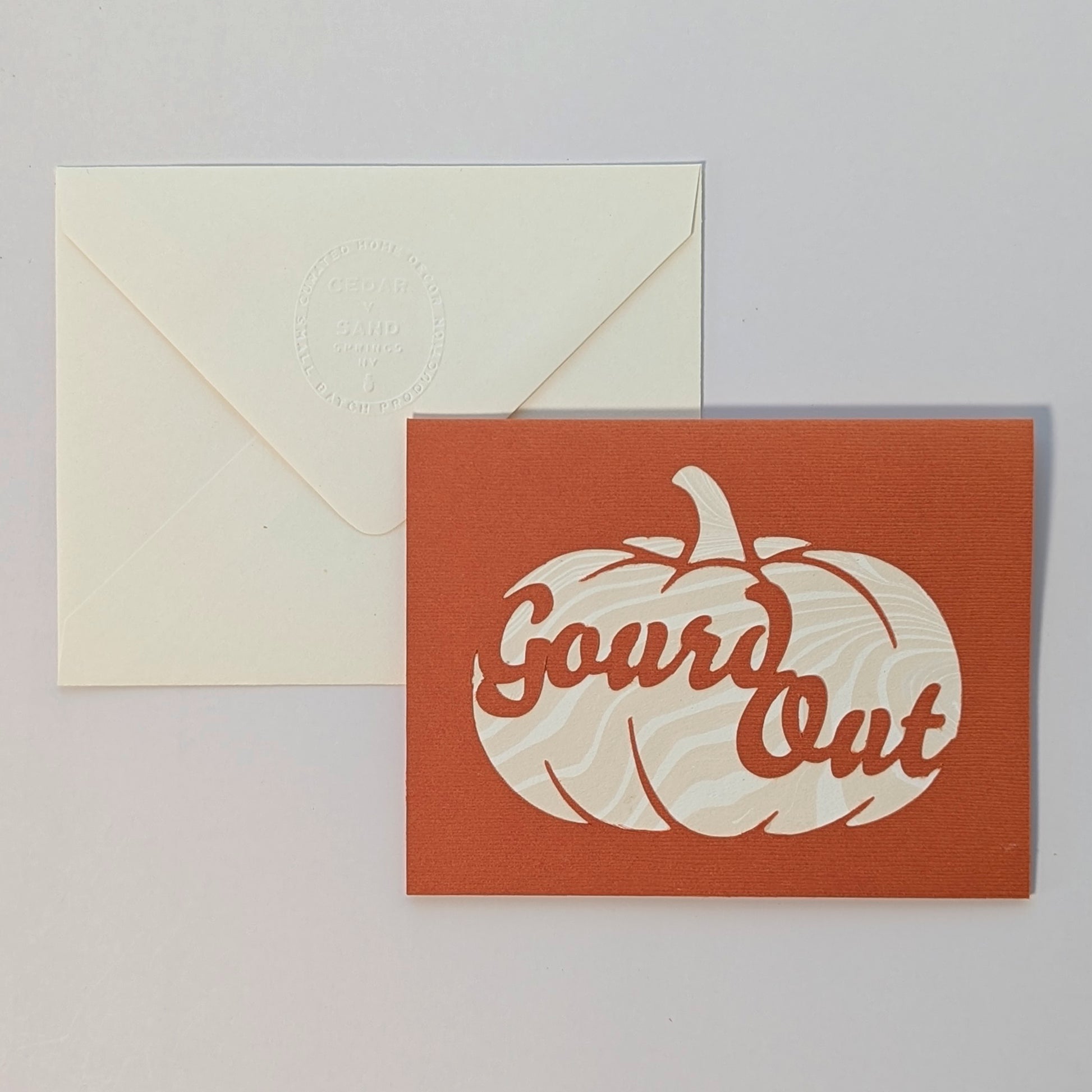 Hand-cut pumpkin Gourd Out notecard with marbled paper backing, paired with embossed cream envelope on neutral background.