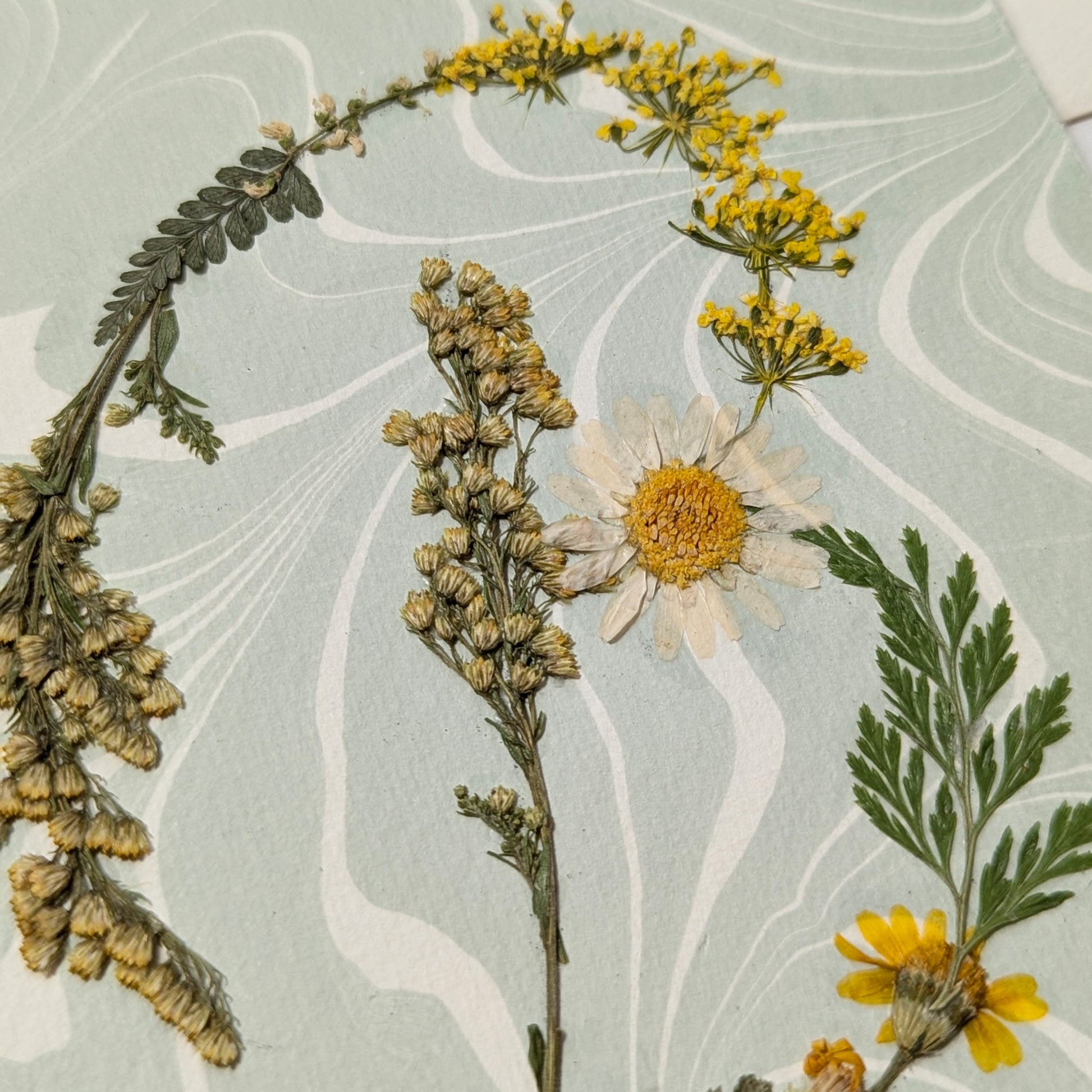Pressed botanical “B” initial notecard with yellow and green florals on soft blue Suminagashi marbled paper, artisan handmade cardstock