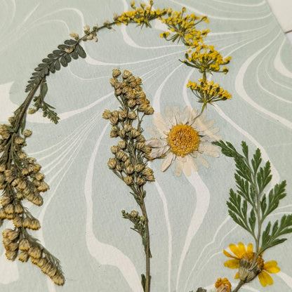 Pressed botanical “B” initial notecard with yellow and green florals on soft blue Suminagashi marbled paper, artisan handmade cardstock