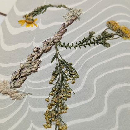 Pressed botanical “K” initial notecard with lavender and wildflowers on Suminagashi marbled background, handmade on Fabriano Medioevalis paper