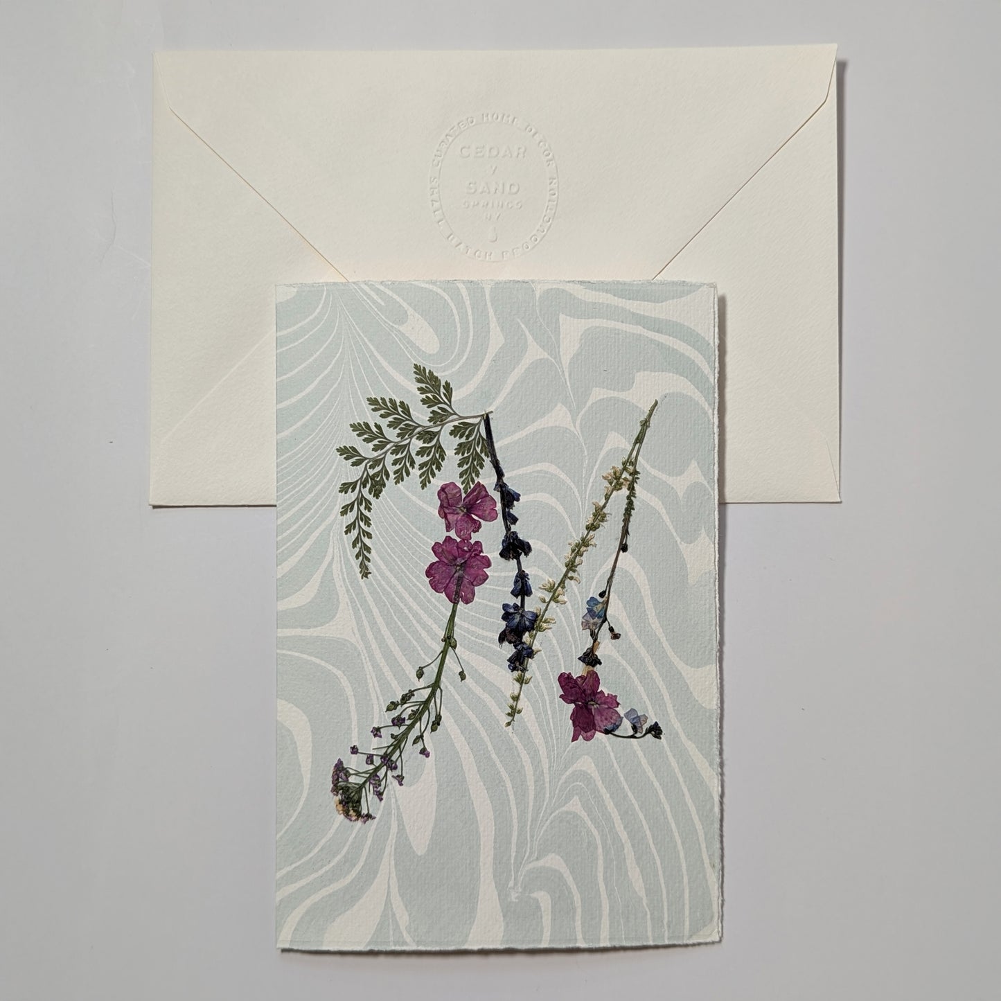 Pressed flower letter M notecard on pale blue Suminagashi paper with envelope, handmade botanical initial card