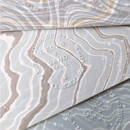 Embossed Cedar Y Sand insignia stamped on the back of a Marine Fauna Fin Series notecard, visible against marbled suminagashi patterns.