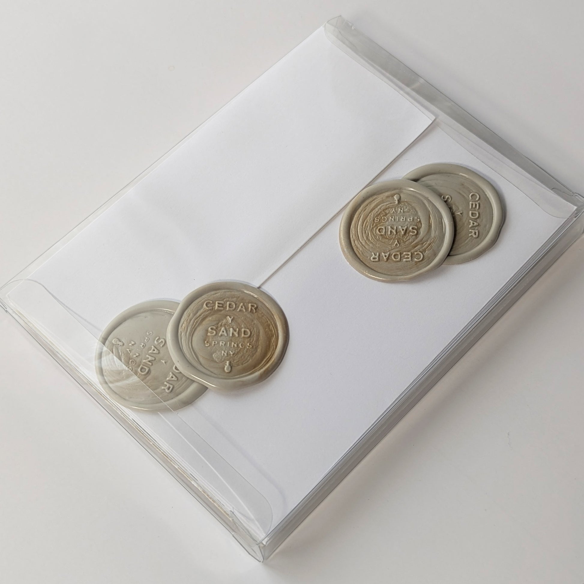 Back view of Marine Fauna Sea Life notecard set packaged in clear box with envelopes and Cedar Y Sand self-adhesive wax seals.
