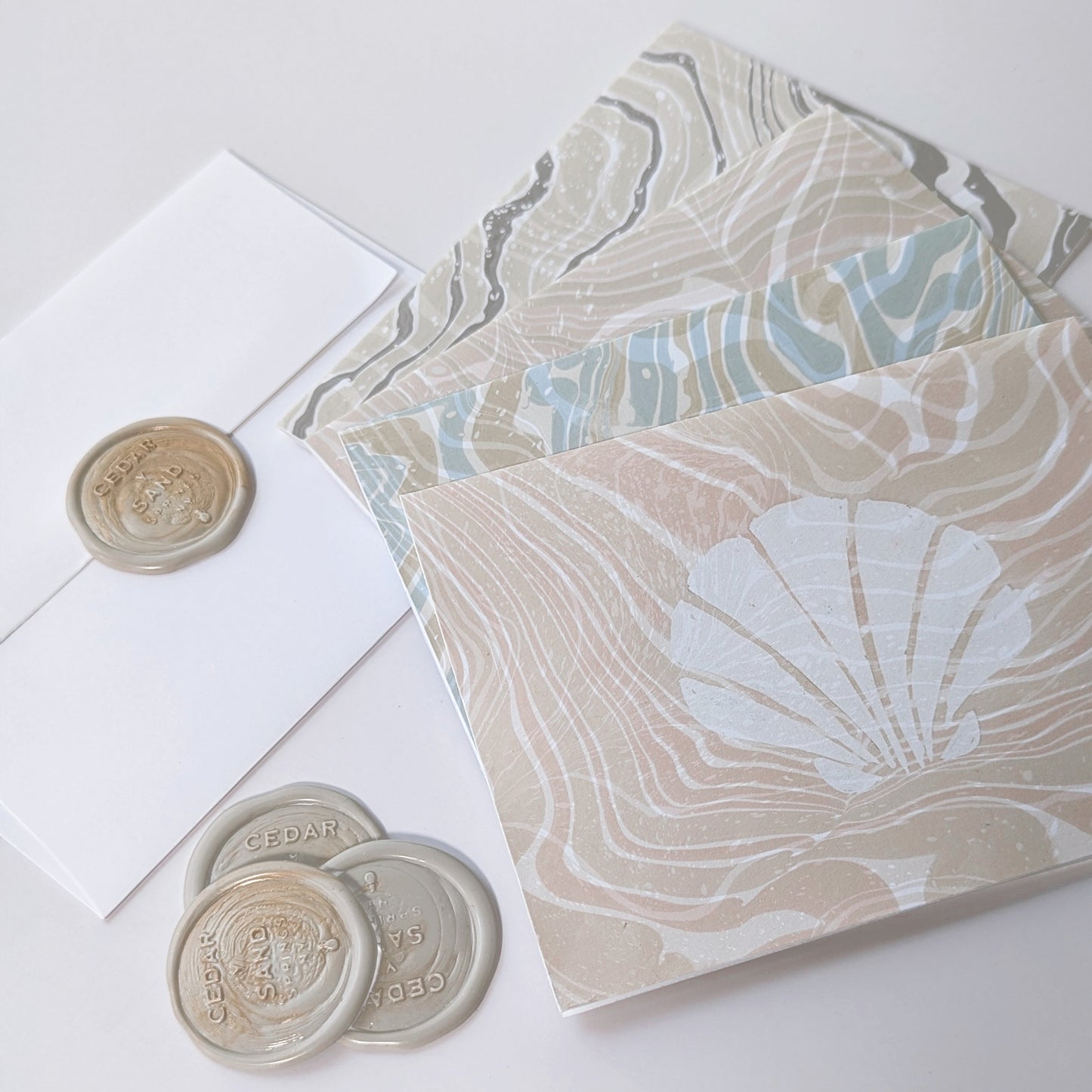 Close-up of Marine Fauna Sea Life notecards showing scallop and marbled suminagashi paper detail wax seals.