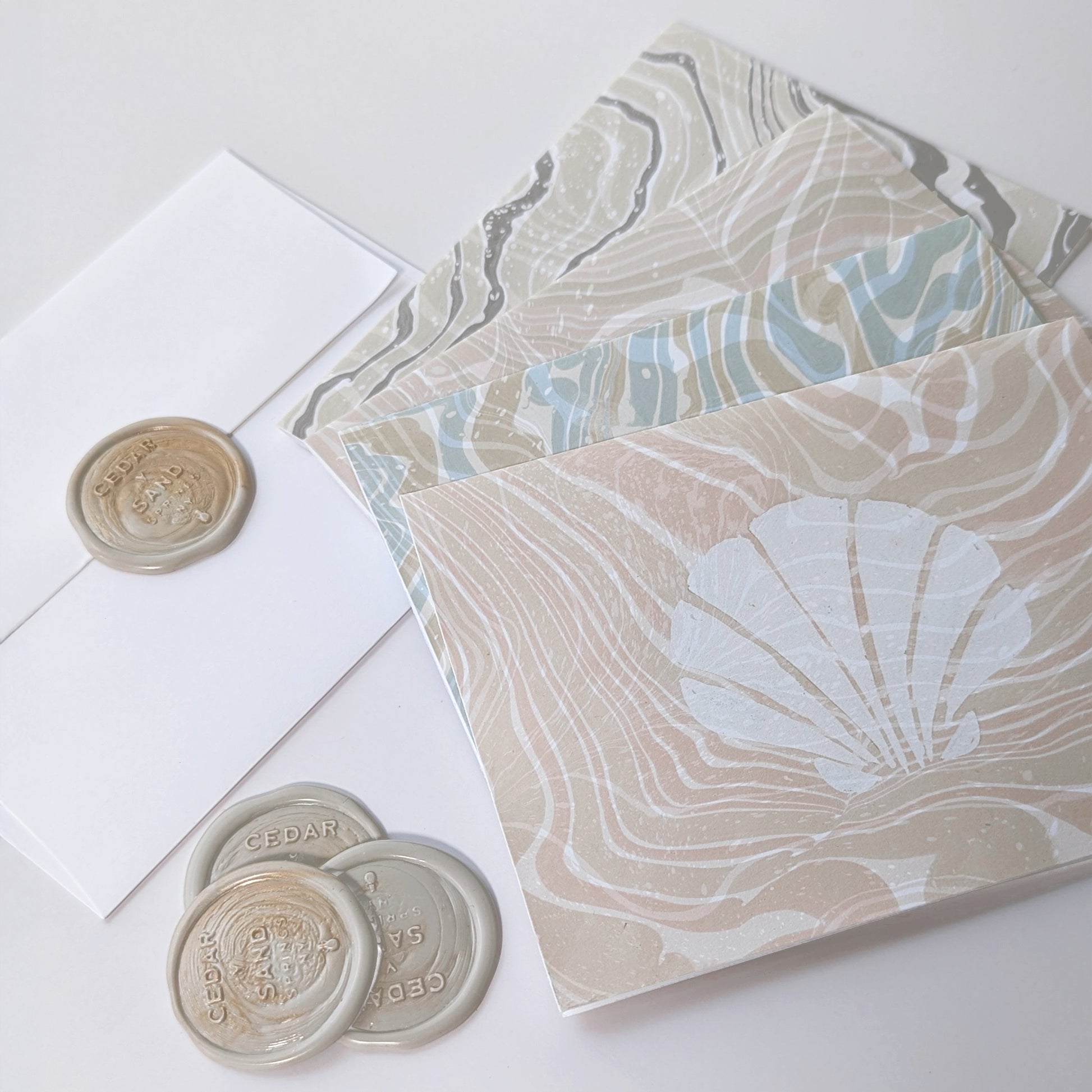 Close-up of Marine Fauna Sea Life notecards showing scallop and marbled suminagashi paper detail wax seals.