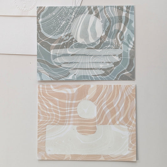 Close-up of Moonset and Sunrise Suminagashi notecards showing marbled textures and celestial masking details.