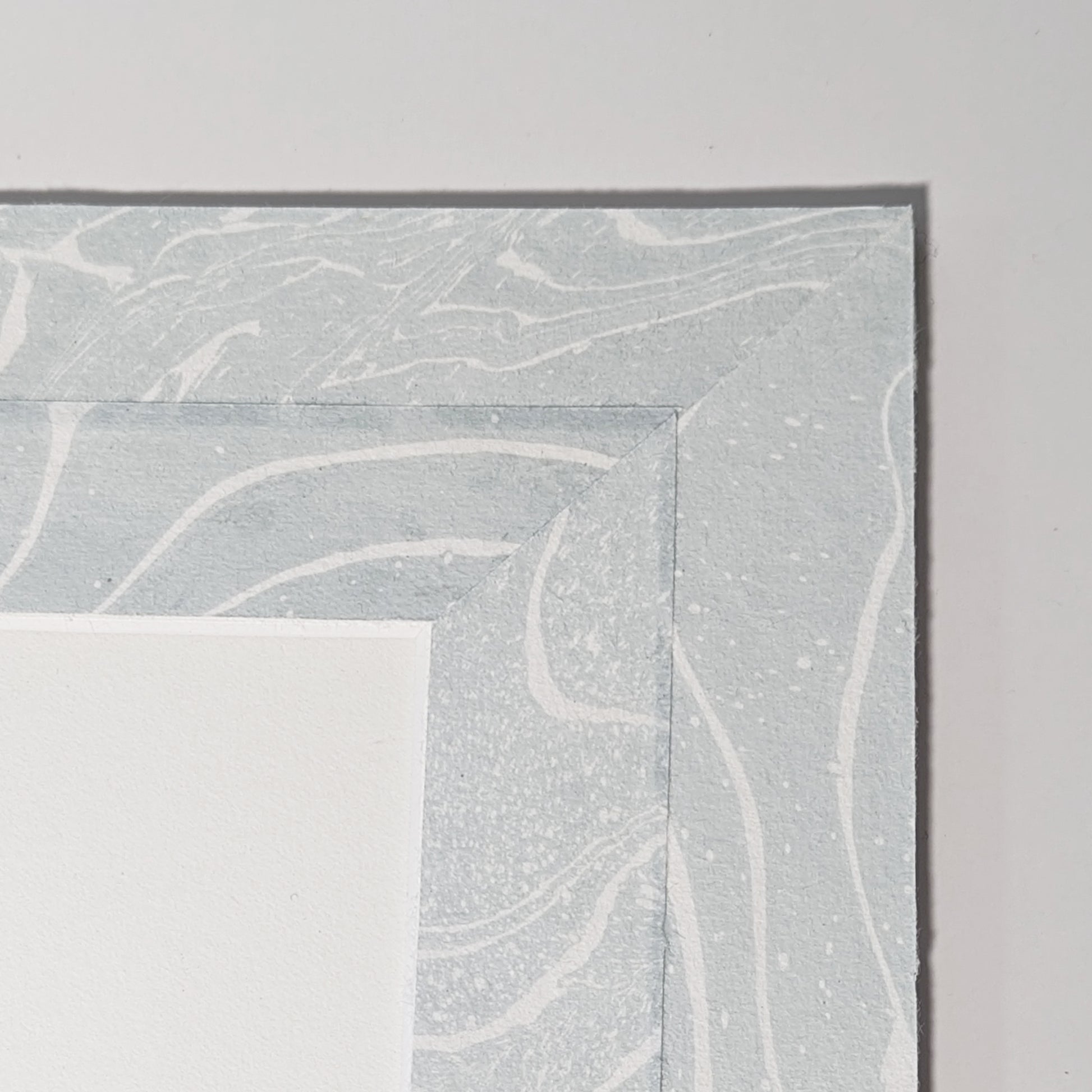 Hand-marbled suminagashi Hosho paper mat detail in soft blue and white swirling patterns