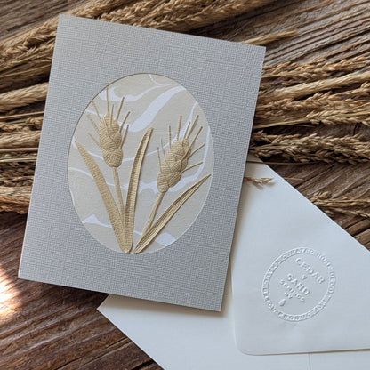 Handmade Wheat Suminagashi notecard styled among dried wheat, featuring dimensional hand-cut paper botanicals by CEDAR Y SAND.