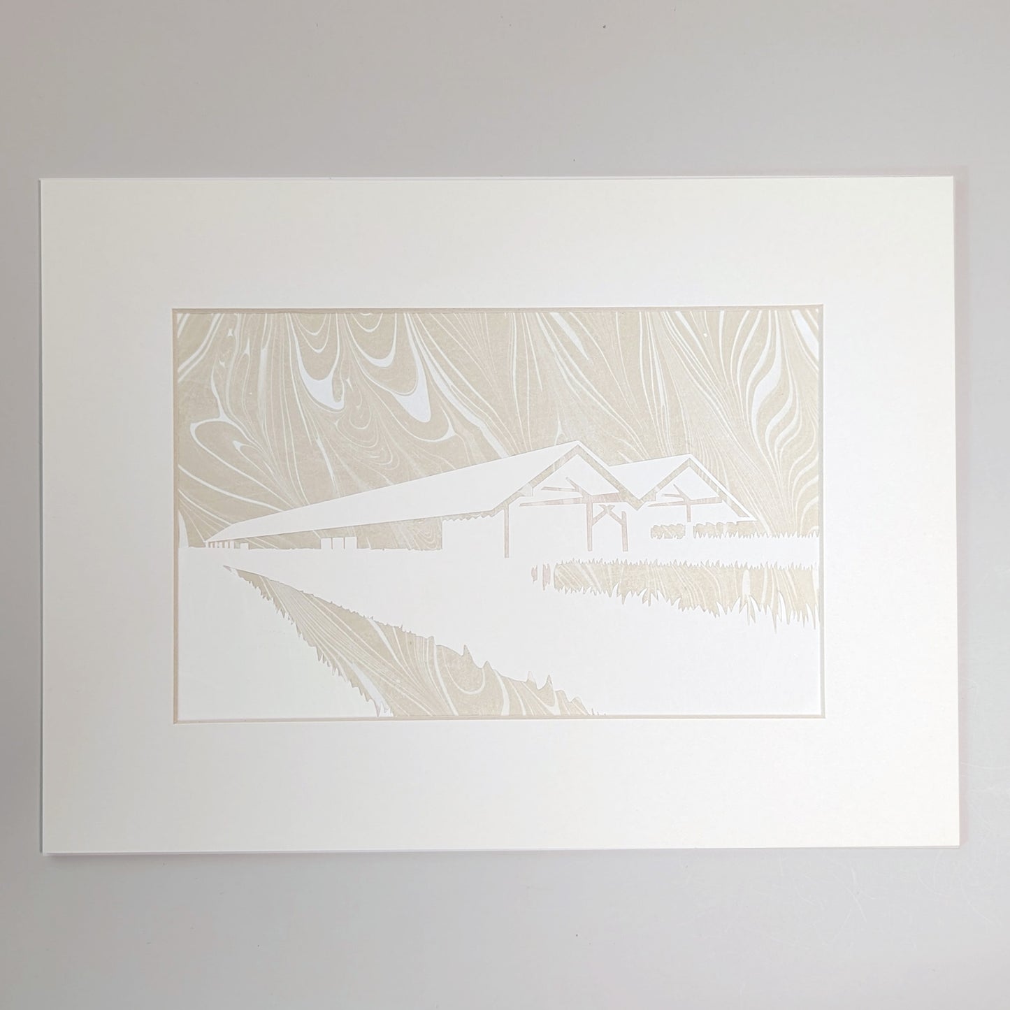 Golden-beige suminagashi marbled paper behind a hand-cut silhouette of the Parrish Art Museum, presented in a natural mat.