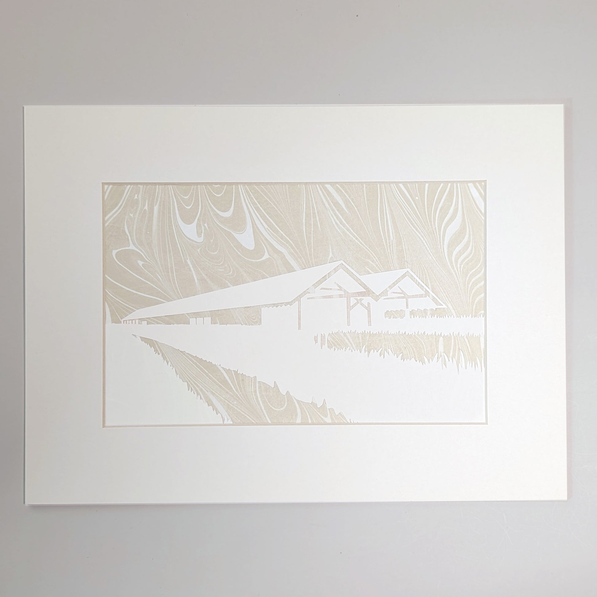 Golden-beige suminagashi marbled paper behind a hand-cut silhouette of the Parrish Art Museum, presented in a natural mat.