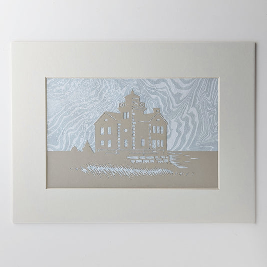 Cedar Point Lighthouse silhouette in dune-toned paper, layered over hand-marbled foggy blue-gray suminagashi background, matted in off white.