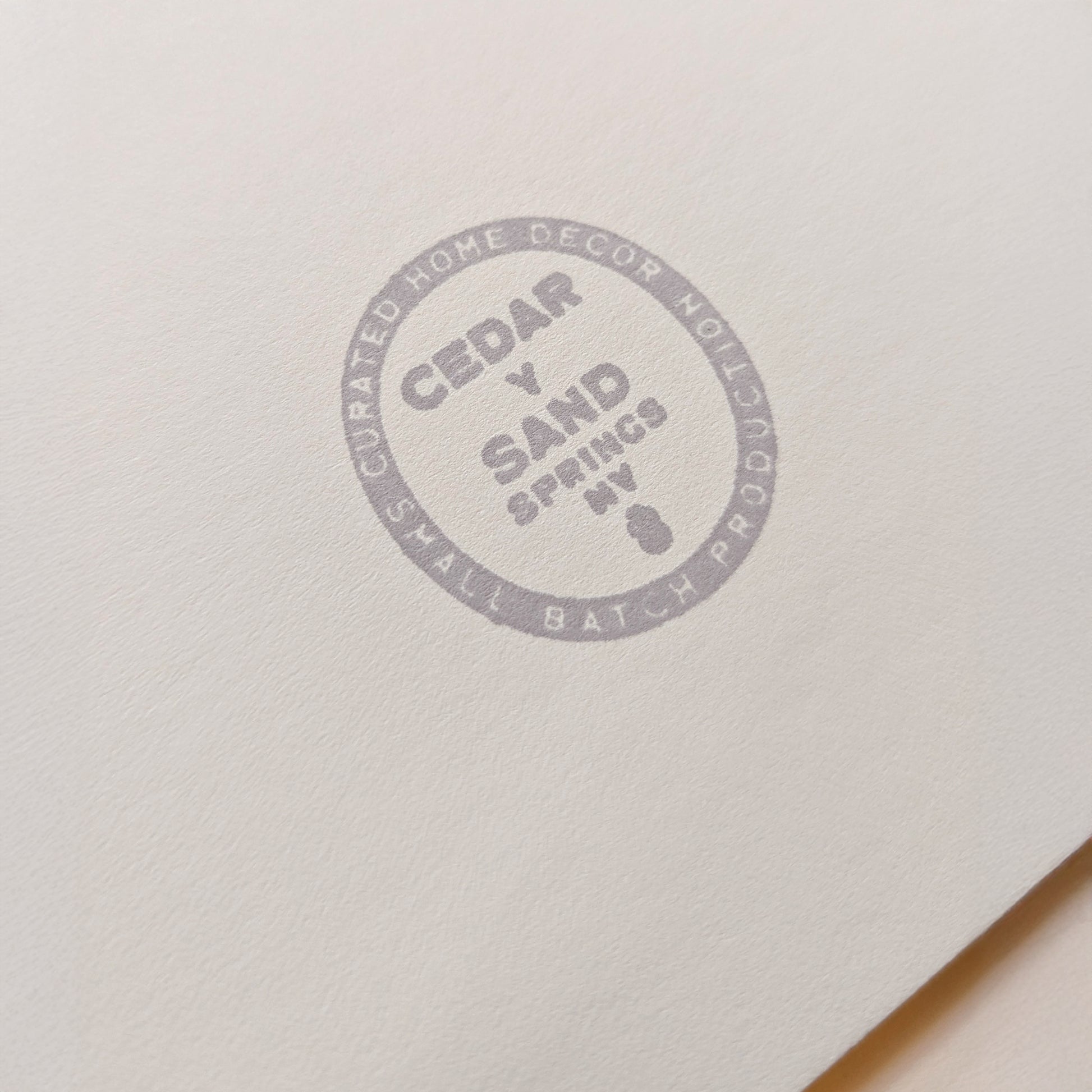 Cedar Y Sand insignia gray back stamp on the backing mat