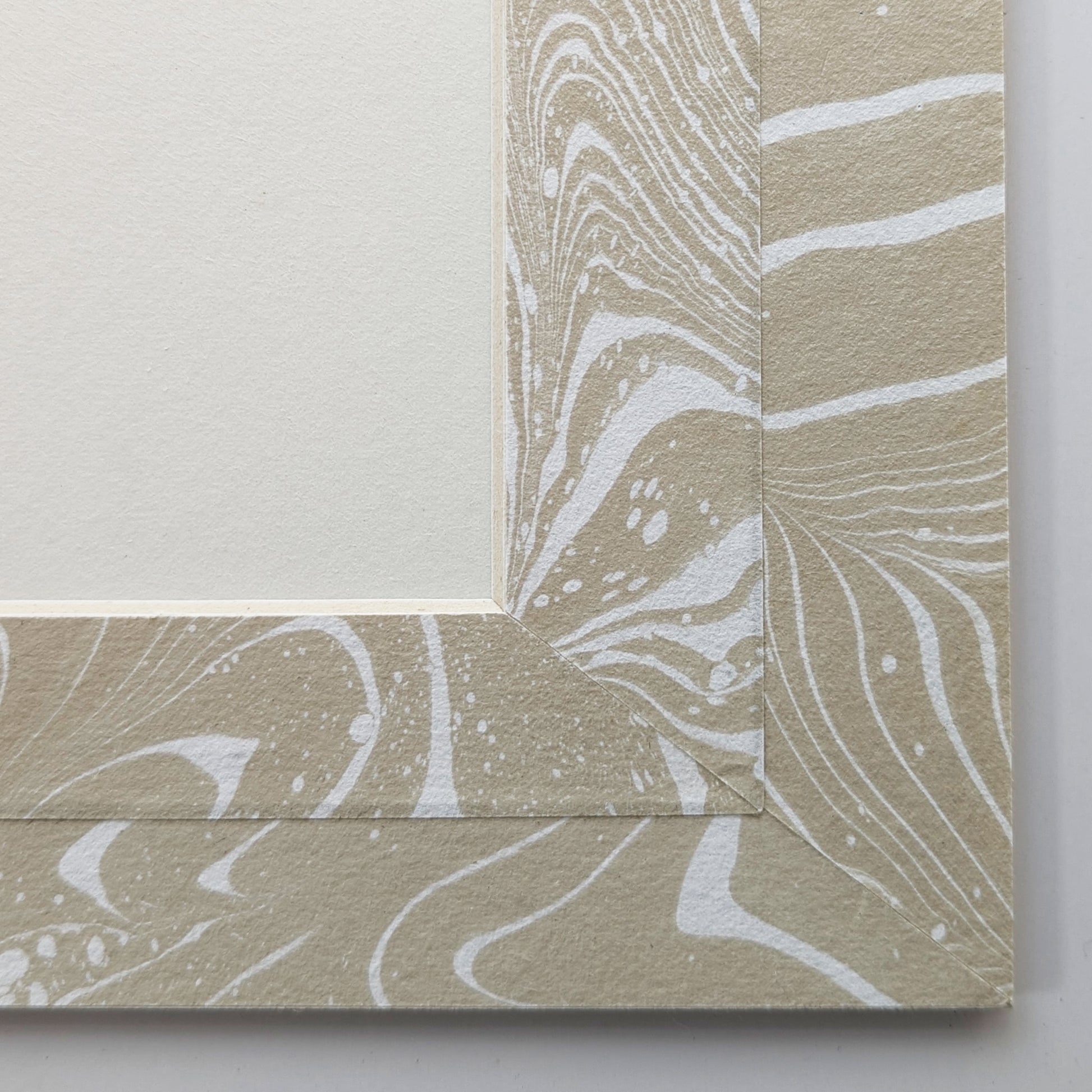 Close view of tan and white suminagashi marbled Hosho paper mat around painting.