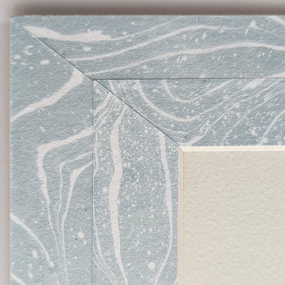Close view of soft blue and white suminagashi marbled Hosho collage paper mat around painting.