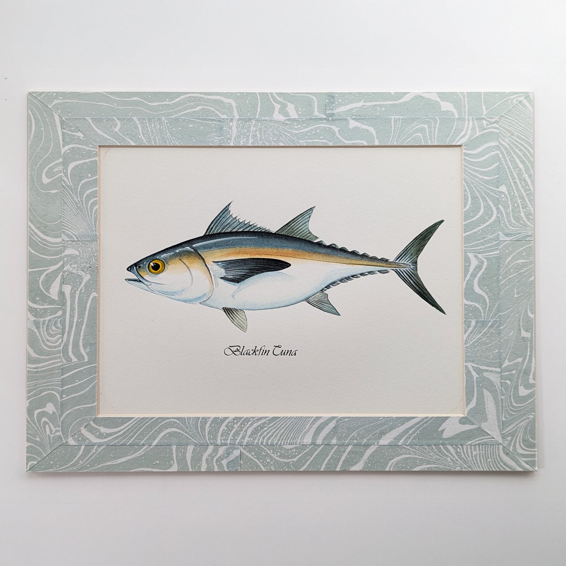 Blackfin Tuna gouache watercolor painting mounted in a blue-white suminagashi collage marbled mat.